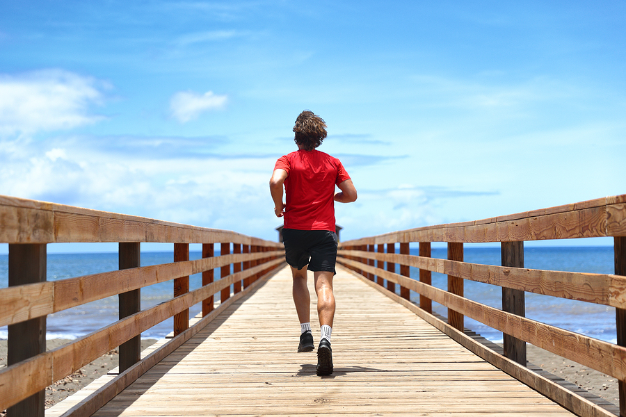 Running runner sport man jogging on beach boardwalk living activ